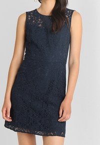 Granatowa sukienka koronkowa o bezrękawowym kroju, w kwiatowy wzór i dopasowanym fasonie, z falbaniastym dołem i teksturowanym materiałem.
