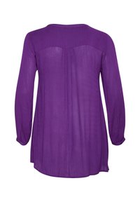 Chemise à manches longues violette avec un col rond, en tissu transparent, et une silhouette fluide. Présente un détail de plis subtil à l'arrière.
