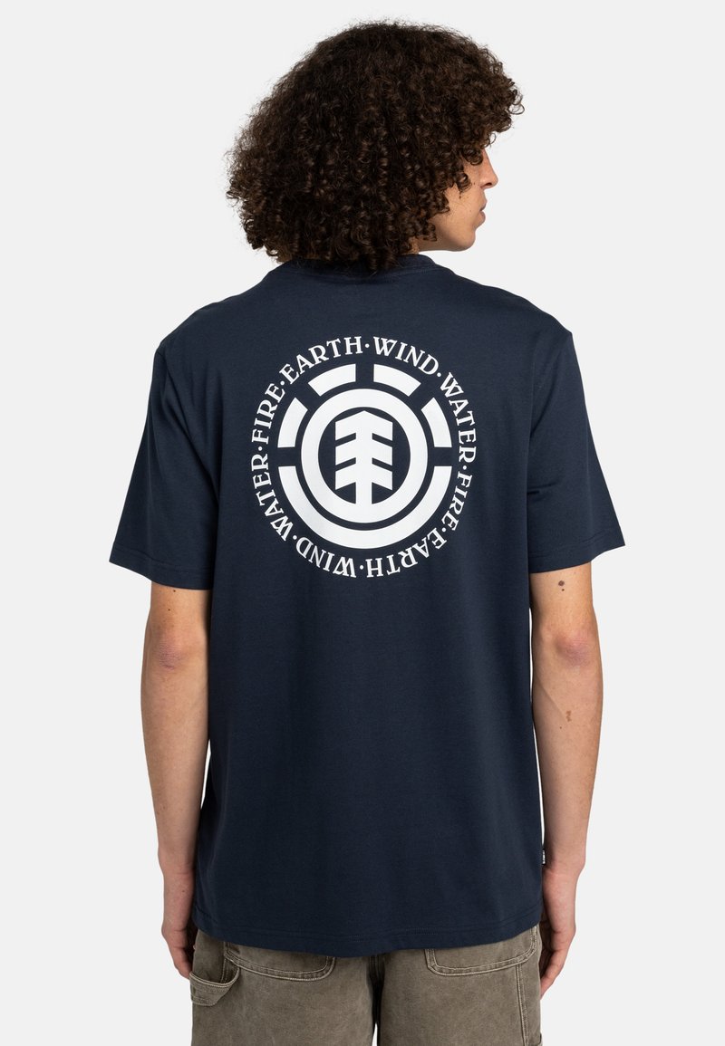 Marineblaue Baumwoll-T-Shirt mit einem kreisförmigen weißen Grafik, die den Text "Wasser, Erde, Wind, Feuer" und ein zentrales Logo auf der Rückseite zeigt.