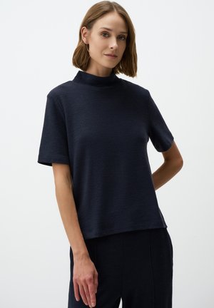 Top a maniche corte di colore blu navy con colletto alto, realizzato in tessuto testurizzato, caratterizzato da una vestibilità comoda e orlo dritto. Design semplice senza motivi.