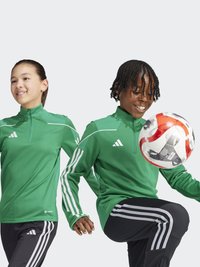 Giubbotti sportivi verdi con accenti bianchi, abbinati a pantaloni neri con tre strisce bianche. I bambini stanno giocando con un pallone da soccer.