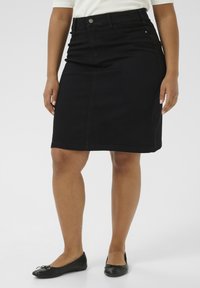 Zwarte denim kokerrok met een aansluitende taille, voorzakken en een lengte tot de knie. Eigenschappen zijn een subtiele textuur en zilverkleurige hardware-details.