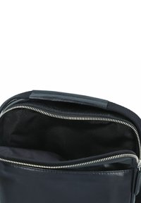 Borsa in pelle blu navy con texture liscia, dotata di hardware in metallo argentato e interno in tessuto nero. Aperta per mostrare il compartimento interno.
