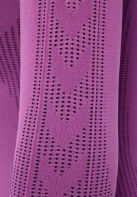 Paarse gebreide stof met een patroon van kleine zwarte stippen die in geometrische vormen zijn gerangschikt, met een gladde textuur en een consistent ontwerp.