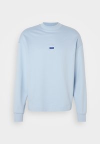 Sweat-shirt bleu clair à manches longues, col ras du cou, poignets côtelés et petit logo rectangulaire bleu "HUGO" centré sur la poitrine.