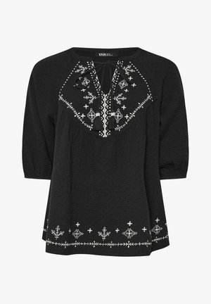 Blusa nera con texture, caratterizzata da motivi floreali ricamati bianchi e un collo con fiocco. Maniche a tre quarti e dettagli di cucitura decorativa.