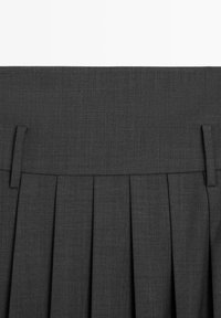 Dark gray pleated skirt with a smooth texture, featuring a wide waistband and two small fabric loops for adjustable fit.