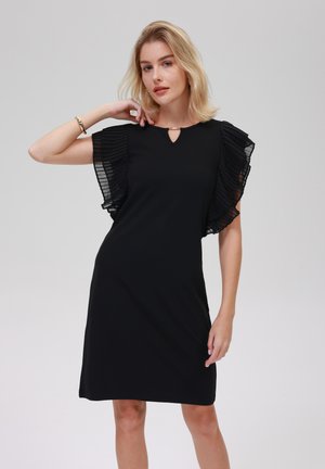 Rochie neagră cu mâneci plisate și transparente. Design cu decolteu în formă de lacrimă. Textură netedă, lungime la nivelul genunchilor, siluetă ajustată. Design simplu și elegant.
