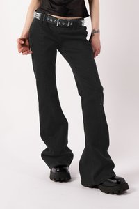 Čierne zvonové džínsy vyrobené z denimu, so štýlovým čiernym koženým opaskom so striebornými dekoráciami a čiernymi platformovými čižmami po členky.