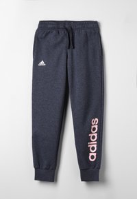 Granatowe spodnie dresowe z elastycznym pasem, ściągaczami i różowym logo "adidas" na lewej nodze. Wykonane z miękkiego, teksturowanego materiału.