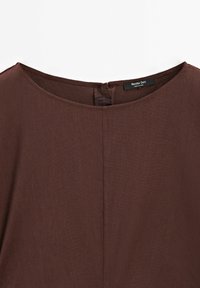 Robe marron avec encolure ronde et fermeture éclair au dos, montrant un gros plan de la partie supérieure avant et de l'étiquette du vêtement.