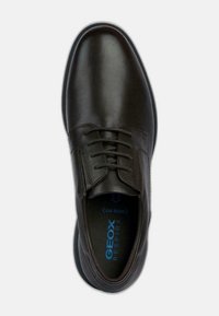 Bruine leren schoen met een gladde afwerking, ronde neus en vetersluiting. Het interieur heeft blauwe "GEOX RESPIRA" branding.