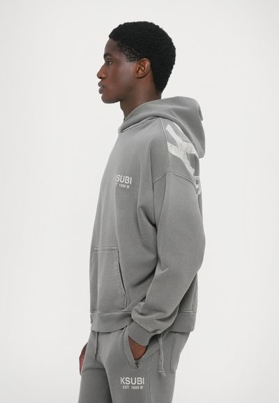 Light grey hoodie made of cotton-blend fabric. Features a kangaroo pocket, ribbed cuffs, and a graphic design on the right shoulder.