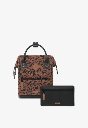 Brown leopard-print plush backpack with black leather accents, top handle, zippers, and a detachable black leather pouch.