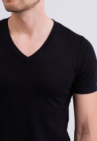 Černé krátké rukávy tričko s výstřihem do V vyrobené z hladké látky, s přiléhavým střihem a minimálními detaily šití.