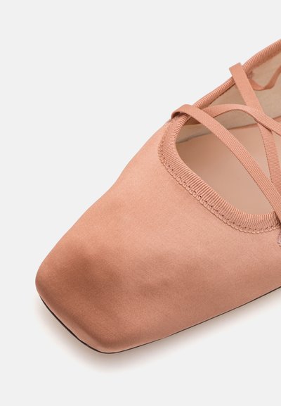 Bailarinas suaves de color rosa con punta cuadrada, material de satén, correas entrelazadas y un detalle de borde cosido en la apertura. Diseño de suela plana.