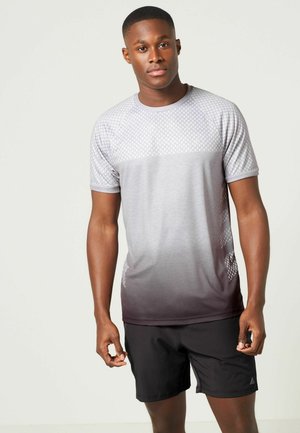 Grå sporty t-shirt med gradienteffekt til mørkegrå, korte ærmer, geometrisk mønster på den øverste del, kombineret med sorte shorts.