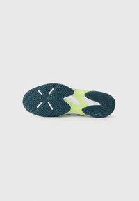 La semelle de chaussure présente un caoutchouc texturé bleu foncé avec des accents blancs et une semelle intermédiaire vert lime ; conçue pour l'adhérence et la stabilité.