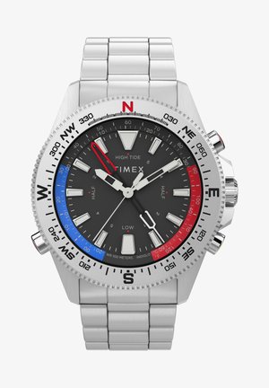 Hodinky Timex High Tide so strieborným nerezovým remienkom. Čierny ciferník obsahuje biele a červené hodinové značky, červené a modré akcenty a kompasový bezél.