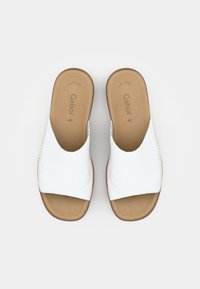 Sandales à enfiler en cuir blanc avec une large lanière et une semelle intérieure beige. Présente des coutures visibles le long des bords et un design minimaliste. Marque Gabor à l'intérieur.