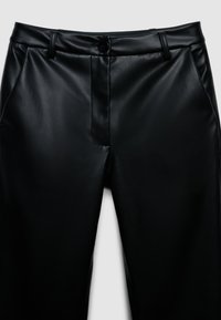 Schwarze Kunstlederhosen mit flachem Bund, sichtbaren Nähten und einem einzigen Knopfverschluss. Sie verfügen über Seitentaschen und eine glatte, glänzende Textur.