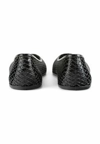 Des ballerines noires avec un motif tissé texturé, un bout arrondi et une semelle en caoutchouc noir. Les chaussures ont un bord lisse le long de l'ouverture.