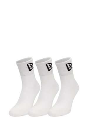 Weiße Knöchelsocken mit geripptem Muster und einem schwarzen Logo am Bund. Drei Paar nebeneinander präsentiert.