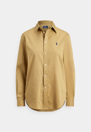 Cămașă bej cu mâneci lungi și nasturi, cu guler ascuțit și logo mic albastru brodat pe pieptul stâng.