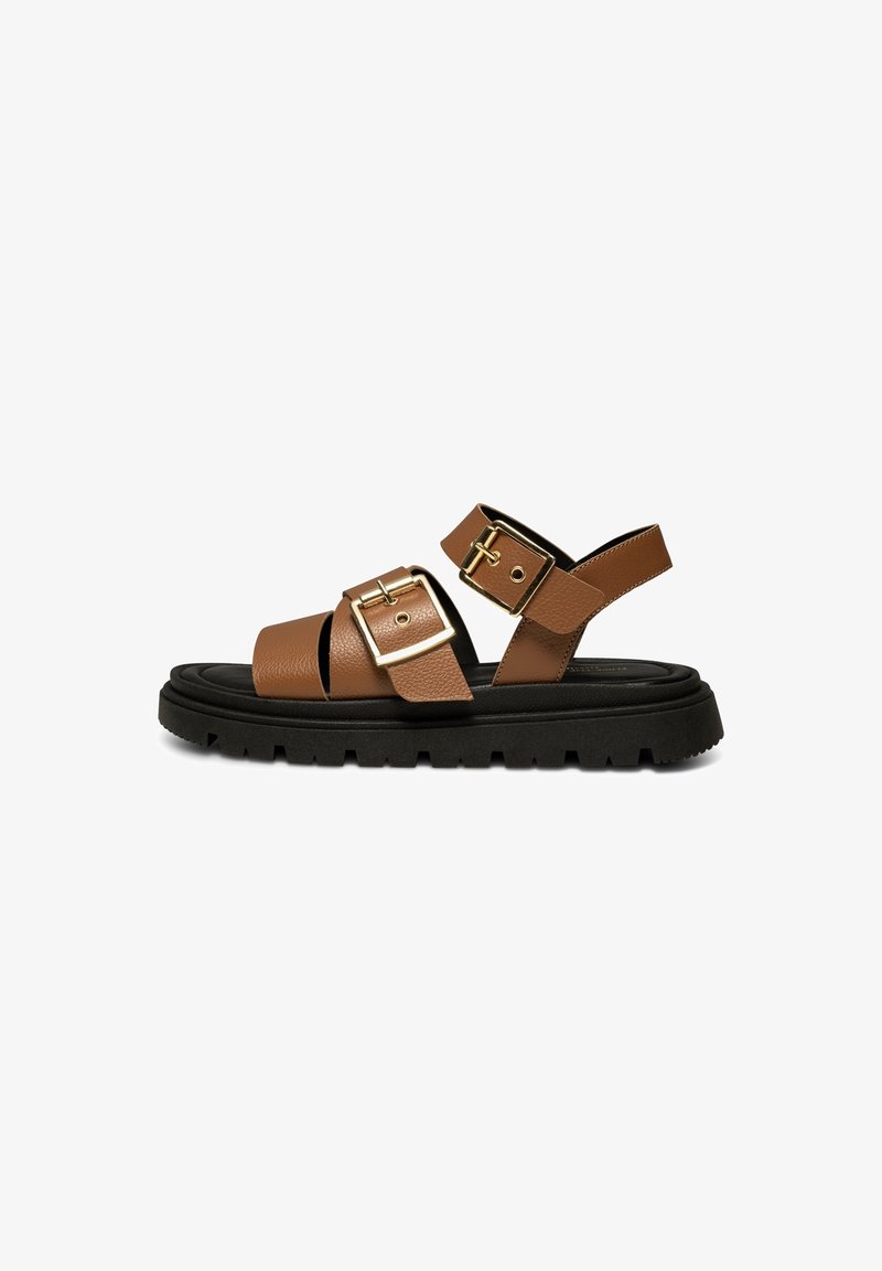 Sandale en cuir marron avec deux boucles dorées réglables, semelle épaisse noire à crampons et design à bout ouvert.