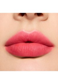 Lèvres roses avec une finition mate, montrant une texture subtile et une coloration uniforme, sur un fond de peau claire et lisse.