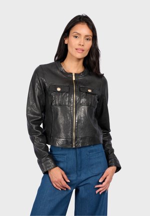 Veste en cuir noir courte avec un col rond, deux poches avant, des fermetures éclair dorées et une texture lisse et brillante.