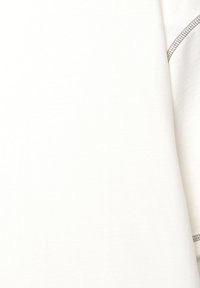 Vit bomull T-shirt med en slät yta, korta ärmar och kontrasterande sömmar längs kanterna. Enkel, oförsköljd design.