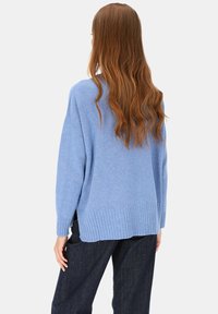 Jasnoniebieski, oversize sweter wykonany z miękkiego materiału, z prążkowanymi mankietami i krawędzią oraz luźnym krojem i nieco dłuższym tyłem.