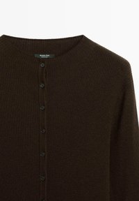 Brown ribbed cardigan with a rounded neckline, featuring a buttoned front and six black buttons, made from textured knit fabric.