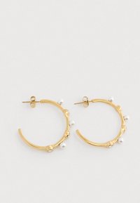 Guld hoops øreringe prydet med små hvide perler og klare krystal accenter på en hvid baggrund.