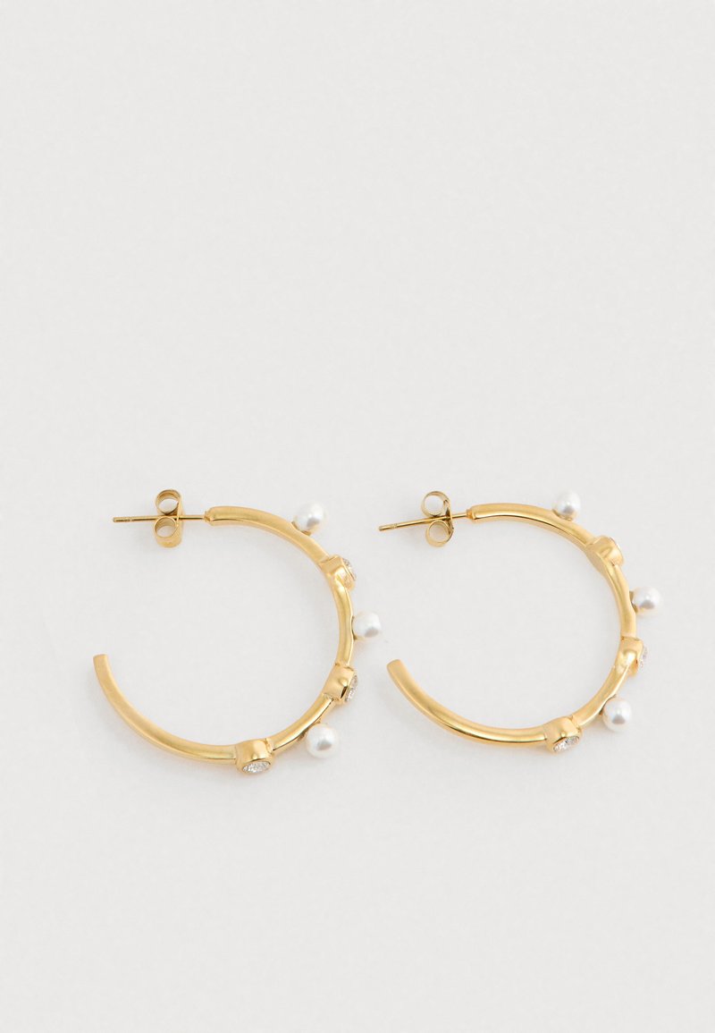 Guld hoops øreringe prydet med små hvide perler og klare krystal accenter på en hvid baggrund.