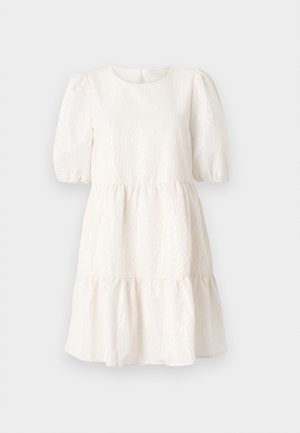 Abito bianco testurizzato con scollatura rotonda, maniche corte a sbuffo e orlo a strati con rouches. Presenta un dettaglio di chiusura sul retro.