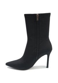 Cizmă neagră până la gleznă realizată dintr-un material neted, având vârful ascuțit, toc stilettos și un fermoar pe lateral cu un tab metallic.