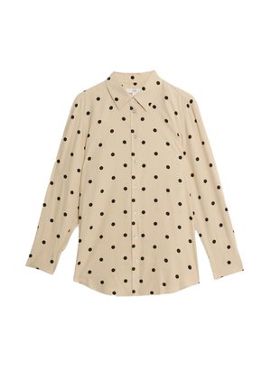 Camisa beige de botones con lunares negros, de manga larga, cuello puntiagudo y cierre frontal con botones. Tejido suave con un ligero brillo.