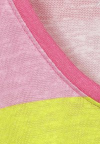 Roze en gele kleurgebroken stof met een zachte textuur, voorzien van een roze halslijn en een gladde, lichte uitstraling.