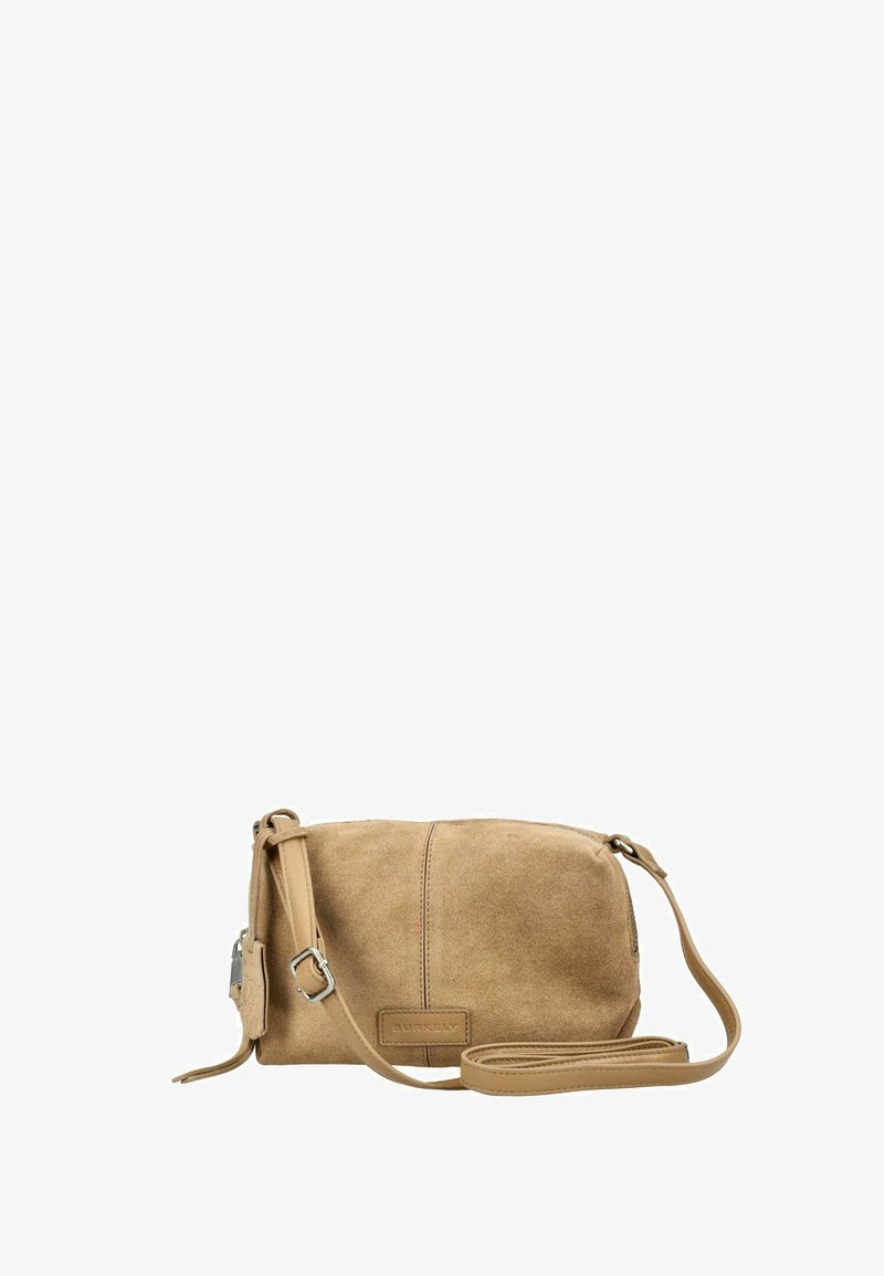 Petit sac bandoulière en daim beige avec une sangle réglable et une boucle argentée, présentant une couture centrale et un écusson avec le logo de la marque.
