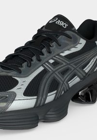 Ανδρικό μαύρο και γκρι παπούτσι για τρέξιμο Asics με πλέγμα στο επάνω μέρος, αντανακλαστικές ρίγες, κορδόνια και κατατμημένη, επενδυμένη σόλα.