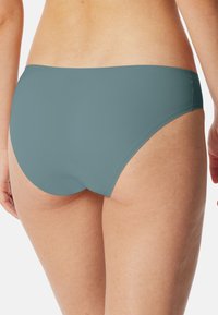 Aqua-colored bikini bottom with a smooth, matte texture, featuring a low-rise design and curved edges for a snug fit.