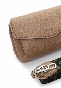 Clutch in finta pelle marrone con texture, dotata di chiusura a pattina, caratterizzata da un logo argento e da una tracolla nera staccabile con motivo e hardware in metallo.