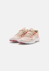Lichte sportieve schoenen met een geweven textuur in roze en crème, met een flexibele witte zool en rode accenten.