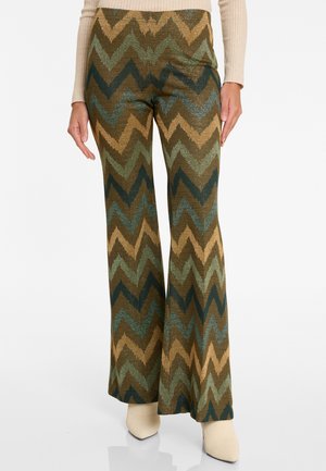 Ausgestellte Hose aus gemustertem Stoff mit Zickzackdesign in erdigen Farbtönen von Grün, Braun und Gold, mit einer gerippten Textur.