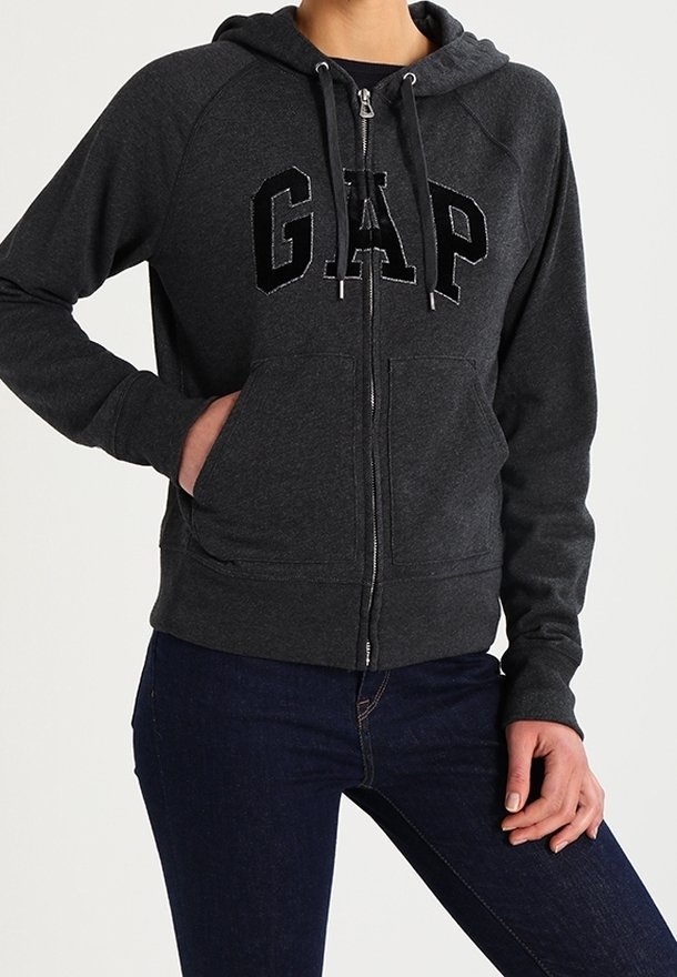 Felpa grigia con zip realizzata in tessuto morbido, dotata di cappuccio, tasche a scomparsa e un audace logo "GAP" ricamato sul davanti.