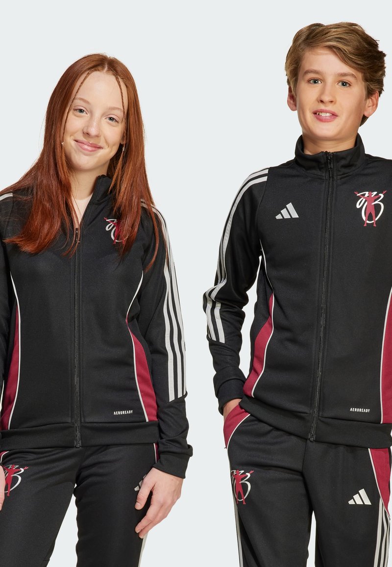 Melnas sportiskās treniņtērpus ar burgundijas akcentiem, baltām sānu svītrām, ar rāvējslēdzēju priekšpusē un logo detaļu uz krūtīm. Poliestera maisījuma audums.