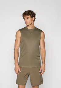 Olivgrünes ärmelloses Shirt aus einem weichen, elastischen Material mit Rundhalsausschnitt, kombiniert mit passenden Shorts, die ein Logodetail aufweisen.