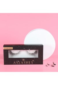 Boxed DIY lash system features long, black, synthetic eyelashes in a clear holder, with a black and gold starry design on the packaging.